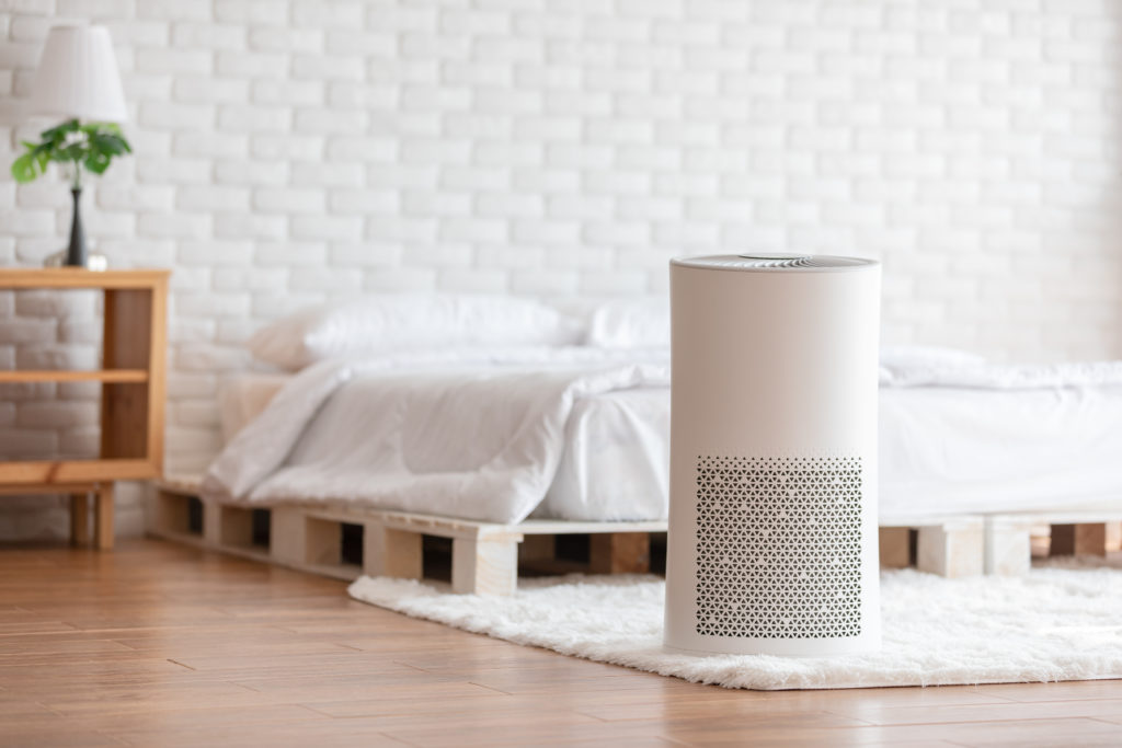 Air purifier in cozy white bed room for filter and cleaning removing dust PM2.5 HEPA in home,for fresh air and healthy life, Air Pollution Concept